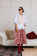 Gonna midi Jolie a fiori rossi e bianchi in cotone, indossata con camicia e gilet – Paglia Milano

Camicia BICE a righe azzurre e bianche in cotone indossata con gonna floreale – Paglia Milano.