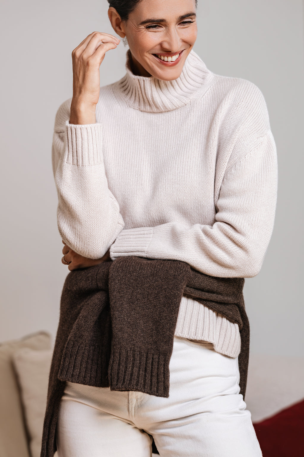 Maglione donna CHALET cipria in 100% cashmere con collo alto e vestibilità ampia, abbinato a camicia bianca e jeans – Paglia Milano.