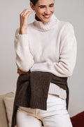 Maglione donna CHALET cipria in 100% cashmere con collo alto e vestibilità ampia, abbinato a camicia bianca e jeans – Paglia Milano.