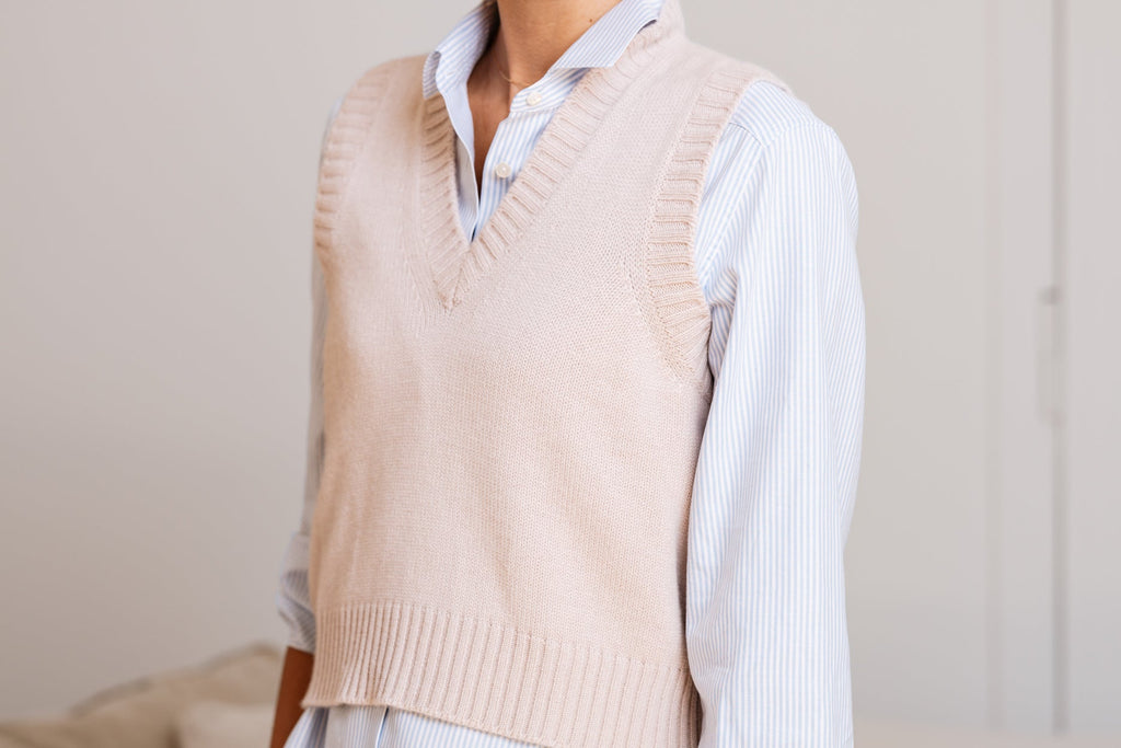 Camicia da donna a righe azzurre con vestibilità morbida, abbinata a maglione e gonna.